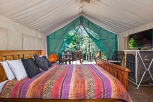 a bedroom with a bed in a tent at Seven Mile Beach Holiday Park in Gerroa