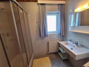 ein Badezimmer mit Waschbecken und Dusche in der Unterkunft Appartements Rosmarie in Fendels