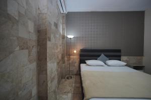 a bedroom with a bed and a stone wall at WABS Syariah in Bandung +96 photos