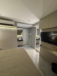 Flat piscina borda infinita a 50m do mar - 214 في جواو بيسوا: غرفه فيها مطبخ فيها سرير