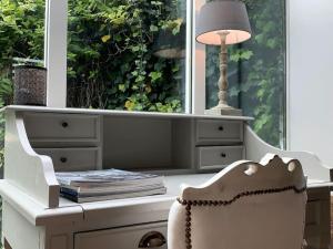 a white desk with a lamp and a chair at Petite Villa de impasse du Prieure in Caen