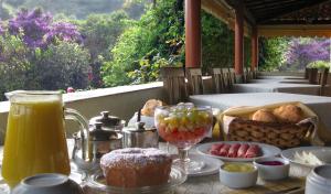 サン・トメー・ダス・レトラスにあるBosque dos Beija-Flores Pousada e Spaのテーブル(上に食べ物と飲み物付)