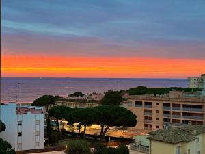 una puesta de sol sobre el océano con edificios y árboles en Perla del Mar, en Platja d'Aro