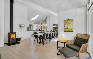 a living room with a table and chairs and a fireplace at Beautiful Home In Væggerløse With Sauna in Marielyst