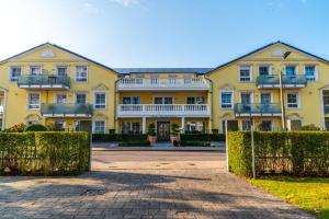 a large yellow house with a driveway at Arkona Strandresidenzen in Binz