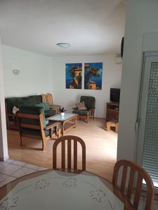 Apartment Sano في بودسترانا: غرفة معيشة بها كراسي وطاولة