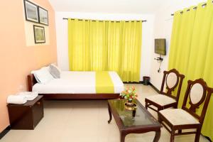 um quarto com uma cama, uma mesa e cadeiras em Elk Hill Palace em Ooty