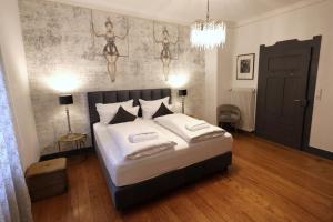 a bedroom with a bed and a wall with mermaid paintings at Villa Delange in Landau in der Pfalz