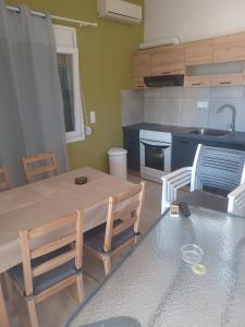 a kitchen with a table and chairs and a sink at Petries Apartment in Petriaí