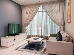 a living room with a couch and a tv at Soho Suites KLCC by Minsha in Kuala Lumpur