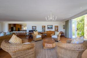 Una sala de estar con sofás y una mesa y sillas. en 22 Sewell Street, en Plettenberg Bay