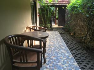 a wooden table and two chairs on a patio at Jessies beach house in Pulau Lutung