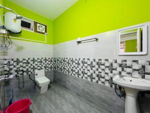 a green bathroom with a toilet and a sink at Kalden Homestay in Dirang Dzong