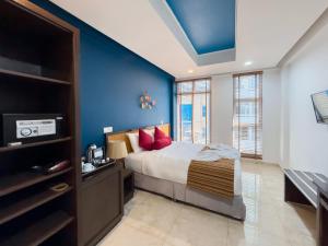 マレにあるNoovila Grand Hulhumale' Maldives澜酒店の青い壁のベッドルーム1室(ベッド1台付)