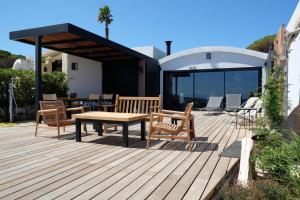 a wooden deck with a table and chairs on a house at Maison les pieds dans l'eau in Lumio