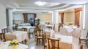 a restaurant with tables and chairs with white tablecloths at Nettuno Hotel Palace in Belvedere Marittimo