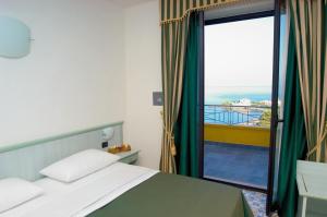 a bedroom with a bed and a view of the ocean at Nettuno Hotel Palace in Belvedere Marittimo +24 photos