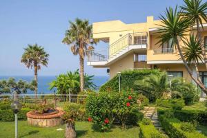 a building with palm trees and flowers in front of it at Nettuno Hotel Palace in Belvedere Marittimo