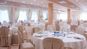 a banquet hall with white tables and chairs at Nettuno Hotel Palace in Belvedere Marittimo