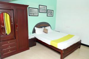 um quarto com uma cama com uma cómoda e um espelho em Elk Hill Palace em Ooty