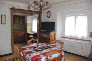 a dining room with a table and a television at Chez Gilles et Christine in Mieussy