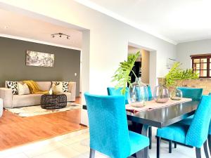 Un comedor con una mesa y sillas azules. en BB Hers Cheesy, en Midrand