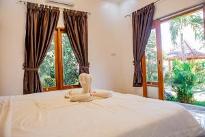 a bedroom with a bed with a large window at Villa Sutra Lovina in Singaraja +43 photos