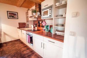 una cucina con mobili bianchi e un piano di lavoro in legno di Auszeithof Niederfrohna a Niederfrohna Altre 107 foto