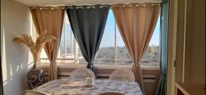a table and chairs in front of a window at La Rose des Sables - face à la mer in Frontignan