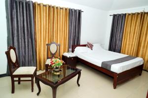 um quarto com uma cama, uma mesa e uma cadeira em Elk Hill Palace em Ooty