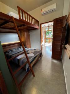 a bedroom with two bunk beds and a television at Flats Theo Peleteiro Praia da concha Flatitacareconcha in Itacaré +46 photos