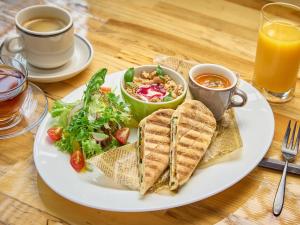 a plate of food with a sandwich and salad and juice at The OneFive Tokyo Shibuya in Tokyo