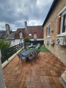a patio with a table and chairs on a deck at Cocon in La Souterraine