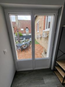 a sliding glass door leading to a patio with a table at Cocon in La Souterraine