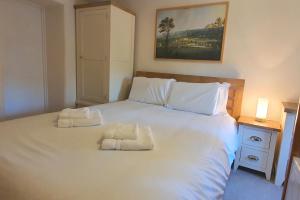 a bedroom with a large white bed with two pillows at Willow Cottage, Youlgrave in Youlgreave