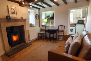 a living room with a couch and a fireplace at Willow Cottage, Youlgrave in Youlgreave