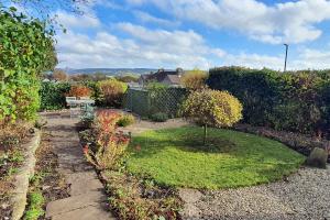 a small garden with a small tree in the middle at Willow Cottage, Youlgrave in Youlgreave +2 photos