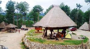 a village with a hut with people and a car at Sagada Heritage Village in Sagada