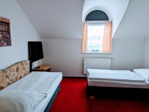 a small bedroom with two beds and a window at Casino & Pension Admiral Dolní Dvořiště in Dolní Dvořiště
