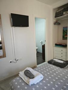 a bedroom with a bed and a tv on the wall at Fantástico ático con terraza, garaje, wifi, con todo para playa, piscina y casa y no facturar maletas! in El Portil +31 photos