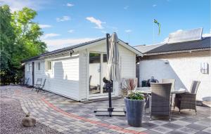 博里霍尔姆Gorgeous Home In Borgholm With Wifi的带露台的房子，露台上配有桌椅