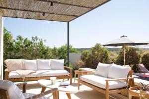 a patio with two couches and an umbrella at Bona Vista - Cala Llonga in Cala Llonga
