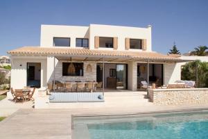 a villa with a swimming pool and a house at Bona Vista - Cala Llonga in Cala Llonga
