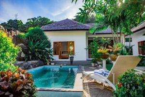 a swimming pool in the backyard of a house at Villa Sutra Lovina in Singaraja
