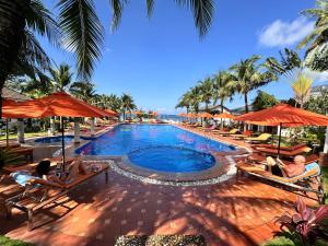 a pool at a resort with people laying on chairs and umbrellas at Orange Resort in Phu Quoc