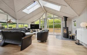 a living room with black leather furniture and a fireplace at Nice Home In Rudkøbing With Sauna in Spodsbjerg