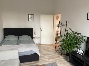 a bedroom with a bed and a plant in it at Direkt am Südstrand! in Wilhelmshaven