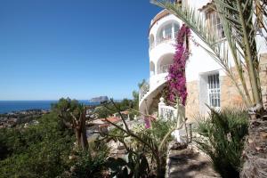 FanadixにあるBellevue - sea view holiday home with private pool in Benissaの紫の花の白い家