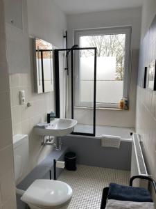 a bathroom with a sink and a toilet and a window at Direkt am Südstrand! in Wilhelmshaven +6 photos