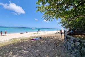 a group of people on a beach near the water at Villa Ti CoCo Elegant Tropical Villa with Pool and Terraces in Trou aux Biches